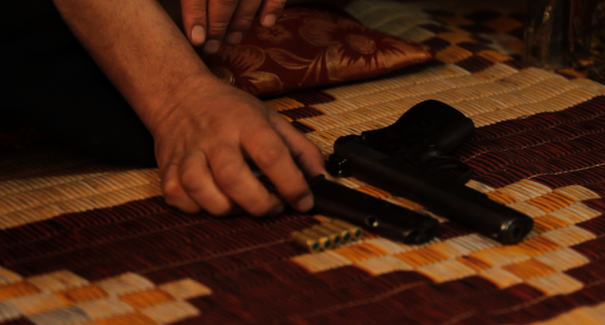 Plainclothes policeman displaying his weapon in <i>Whose Country?</i>. Courtesy of Kino Lorber.